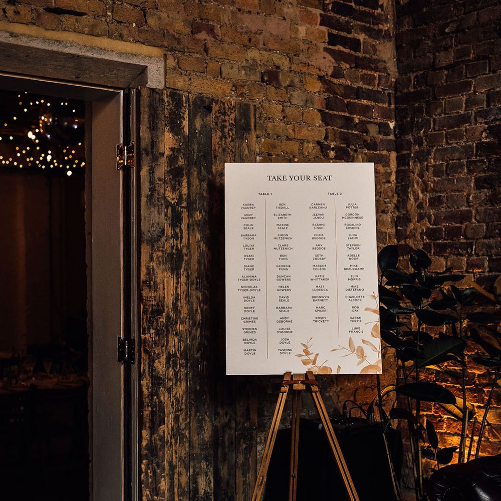 Take your Seat seating chart on a board resting on a wooden easel 