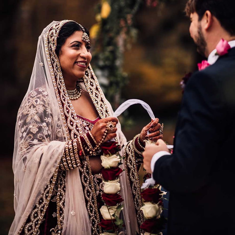 Bride smiles with detailed veil at her Autumn wedding at Minley Manor