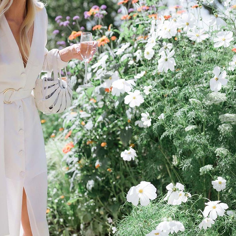 Bon Bride dress with plunging neckline, buttons, long sleeves, belt and front slit with matching white bag 