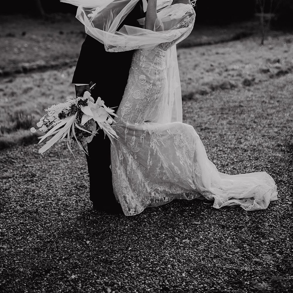 Black tie wedding with tuxedo and lace wedding dress with Watteau train 