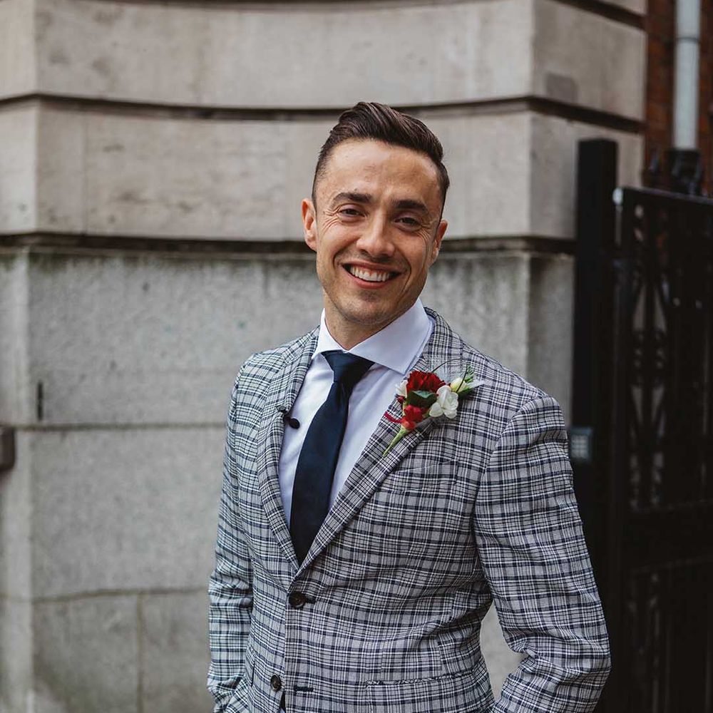 Groom wears grey striped suit complete with floral buttonhole