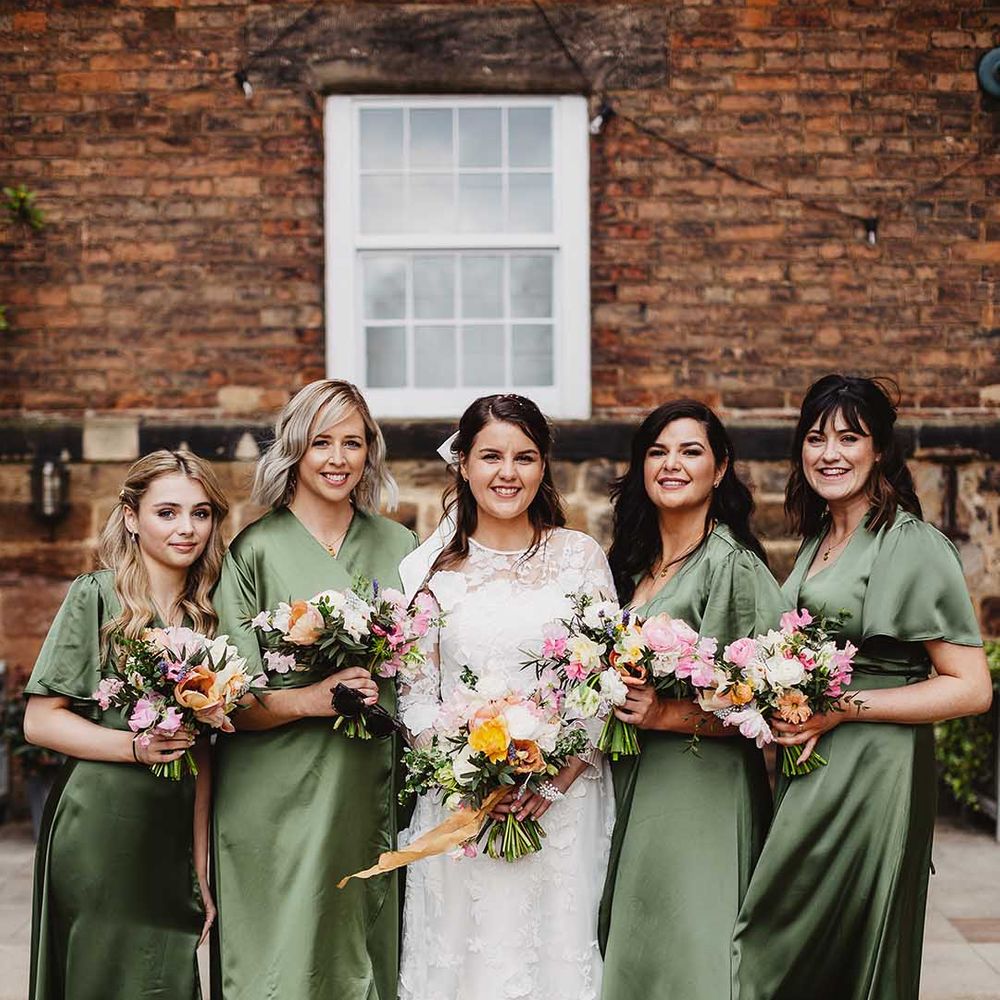 Bridal party with bridesmaids in satin sage green bridesmaid dresses 