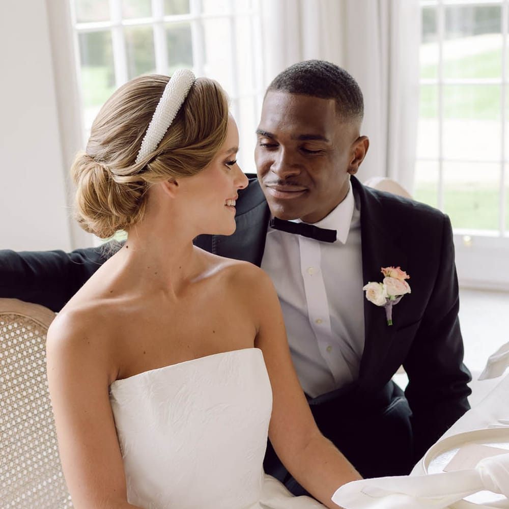 Bride in strapless brocade pattern wedding dress sitting with the groom wearing black tie for Manor House wedding 