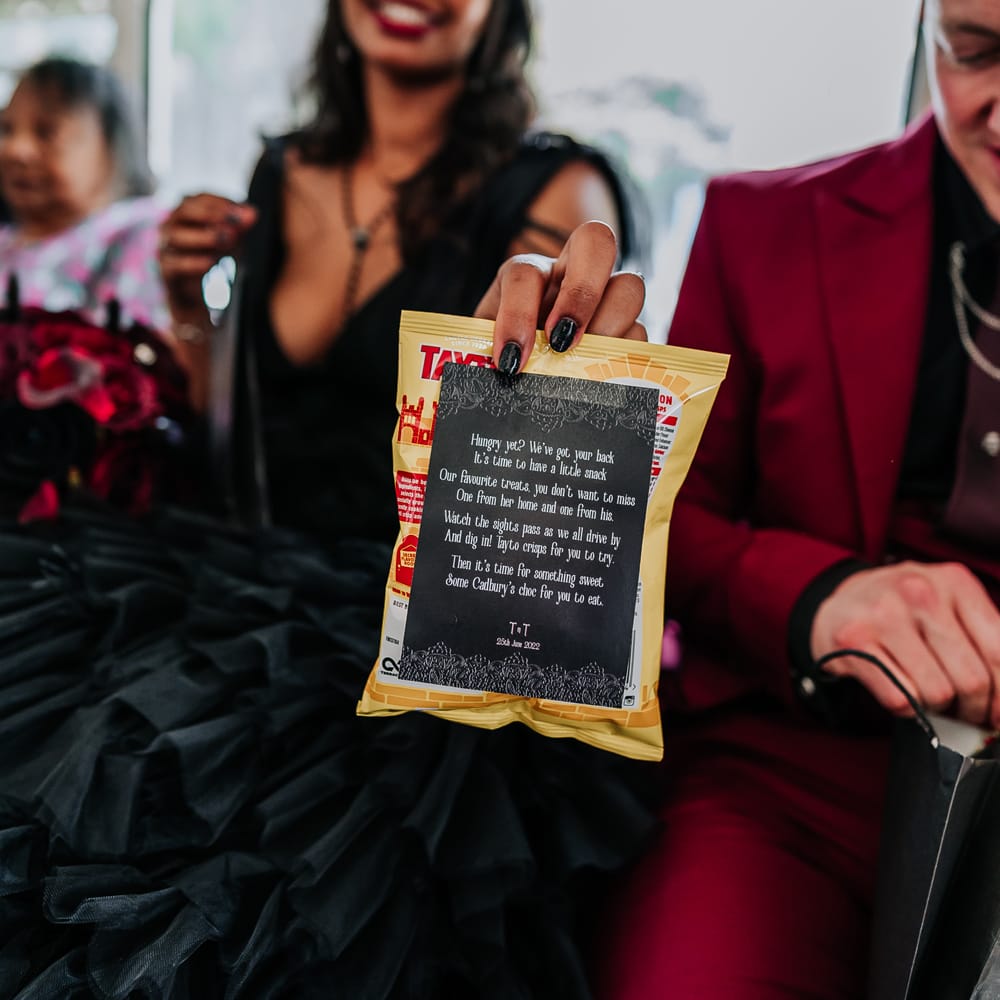 Bride holds personally written poem and bag of Tayto's for snack bag 