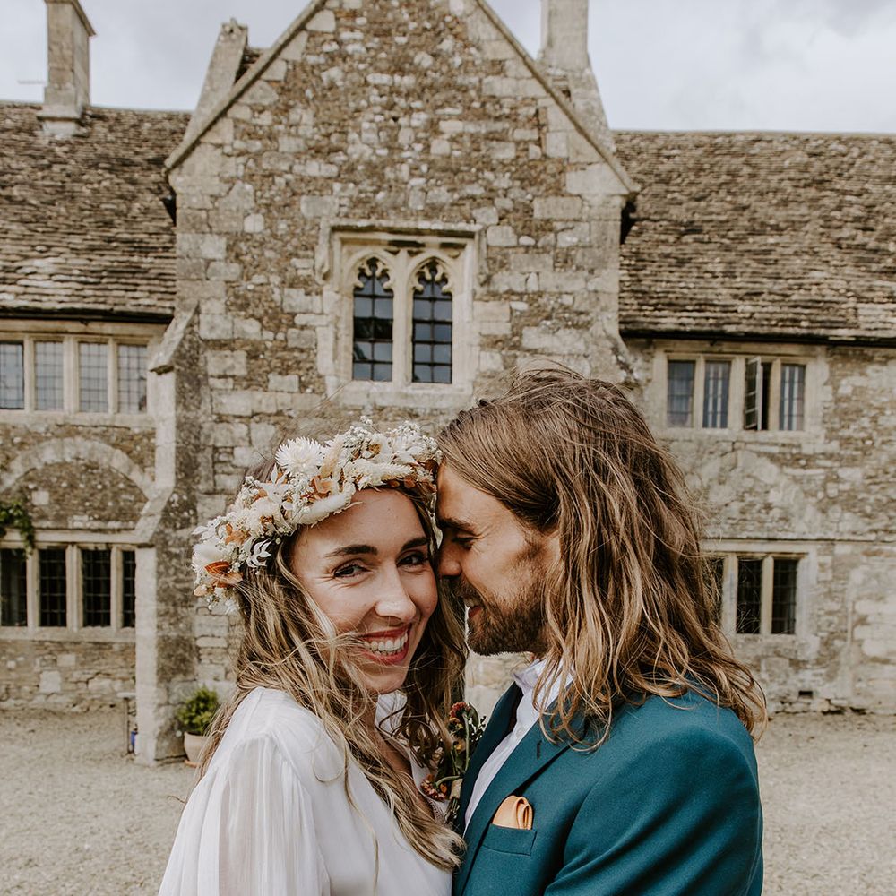 Bride wears floral crown and stands beside her groom 