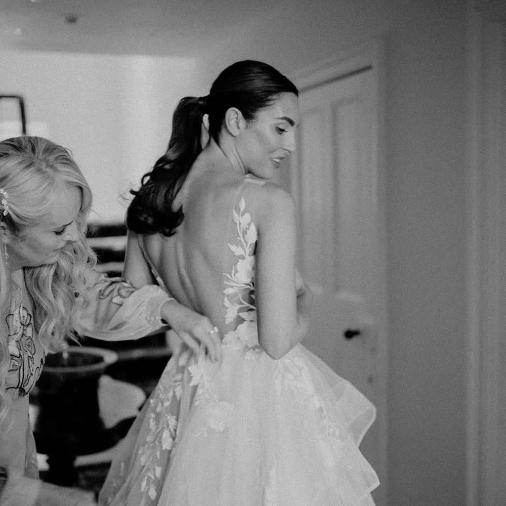 Bridal preparations begin as the bride gets helped into her Wtoo by Watters wedding dress