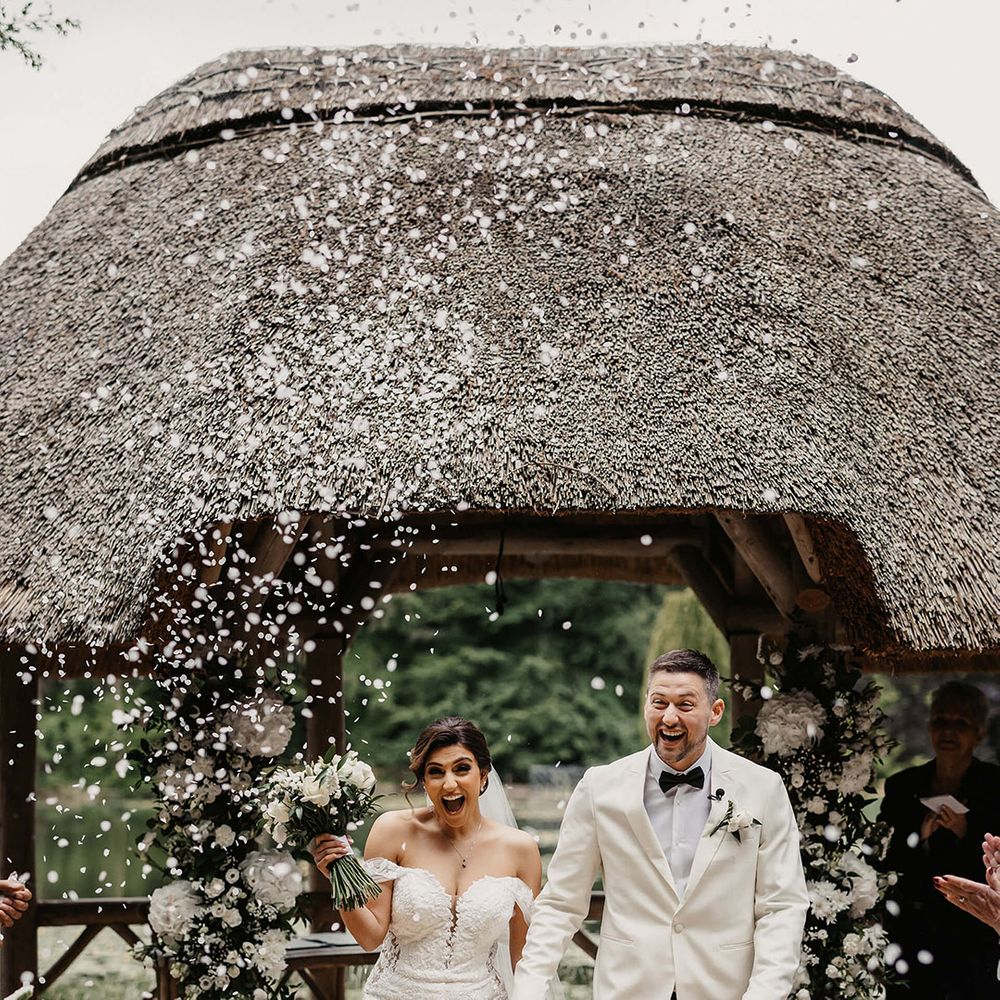 Bride and groom can't contain their excitement as they walk back down the aisle to white confetti 