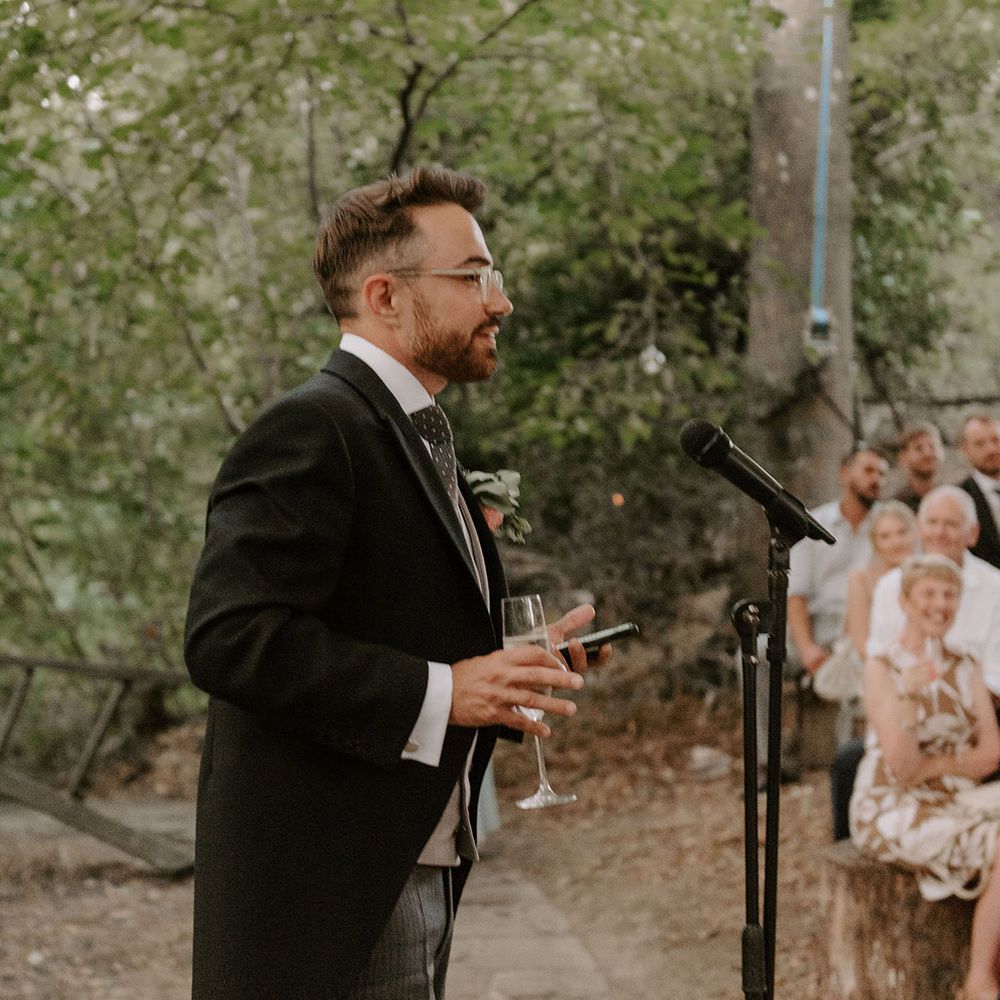 Groom stands up with a microphone as heads out his groom speech 