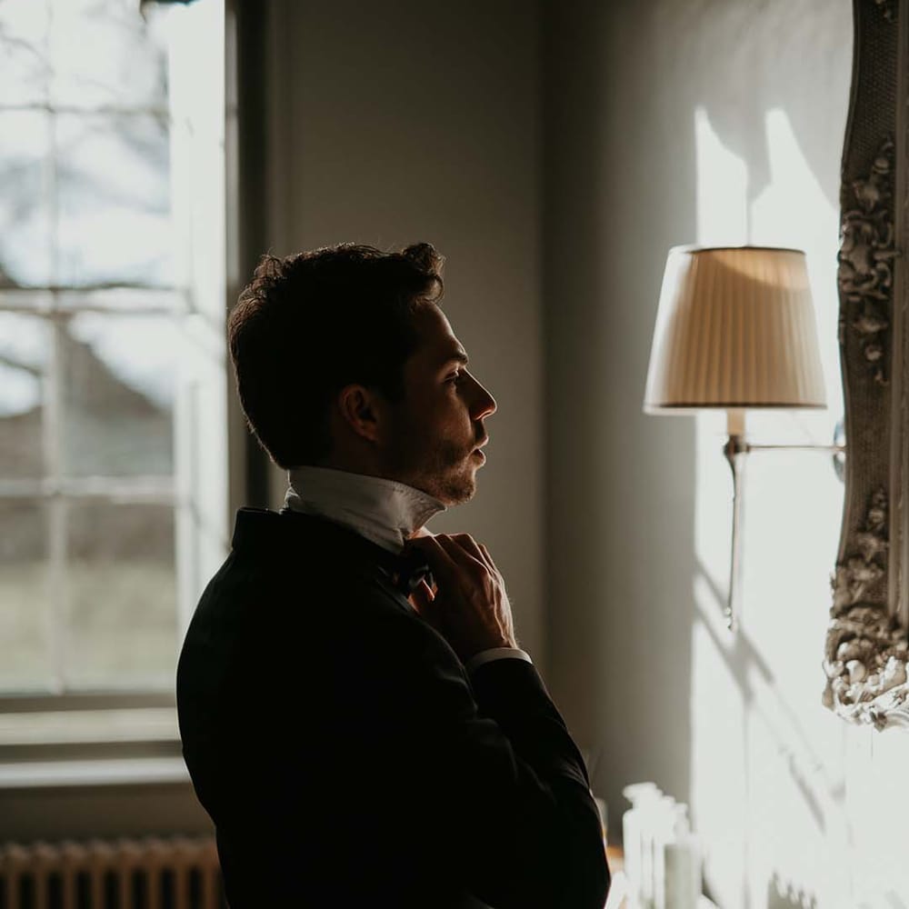 Groom in classic black tux getting ready for rock and roll wedding 