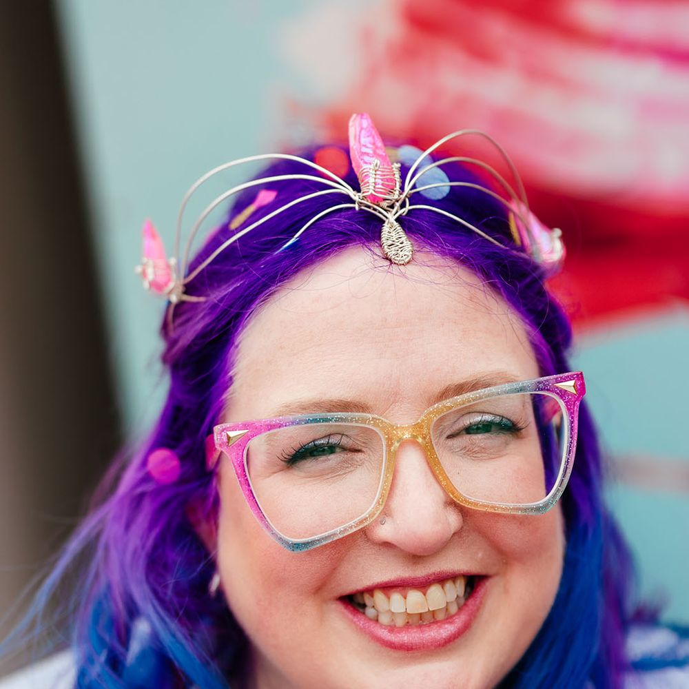 Bride with vibrant purple and blue hair with gemstone bridal crown and multicoloured glasses 