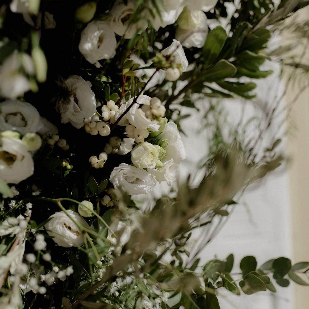 Greek wedding floral decor including white berries, italian ranunculus and eucalyptus
