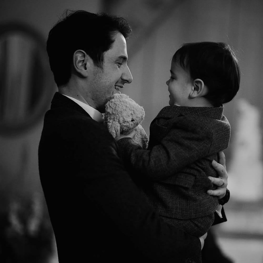 Groom carrying their page boy with little teddy 