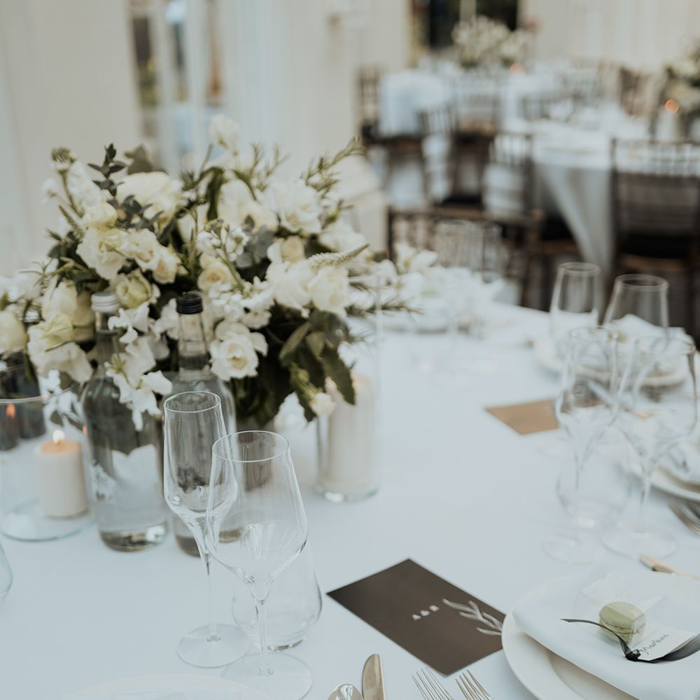elegant place setting with white flower and green foliage centrepiece 