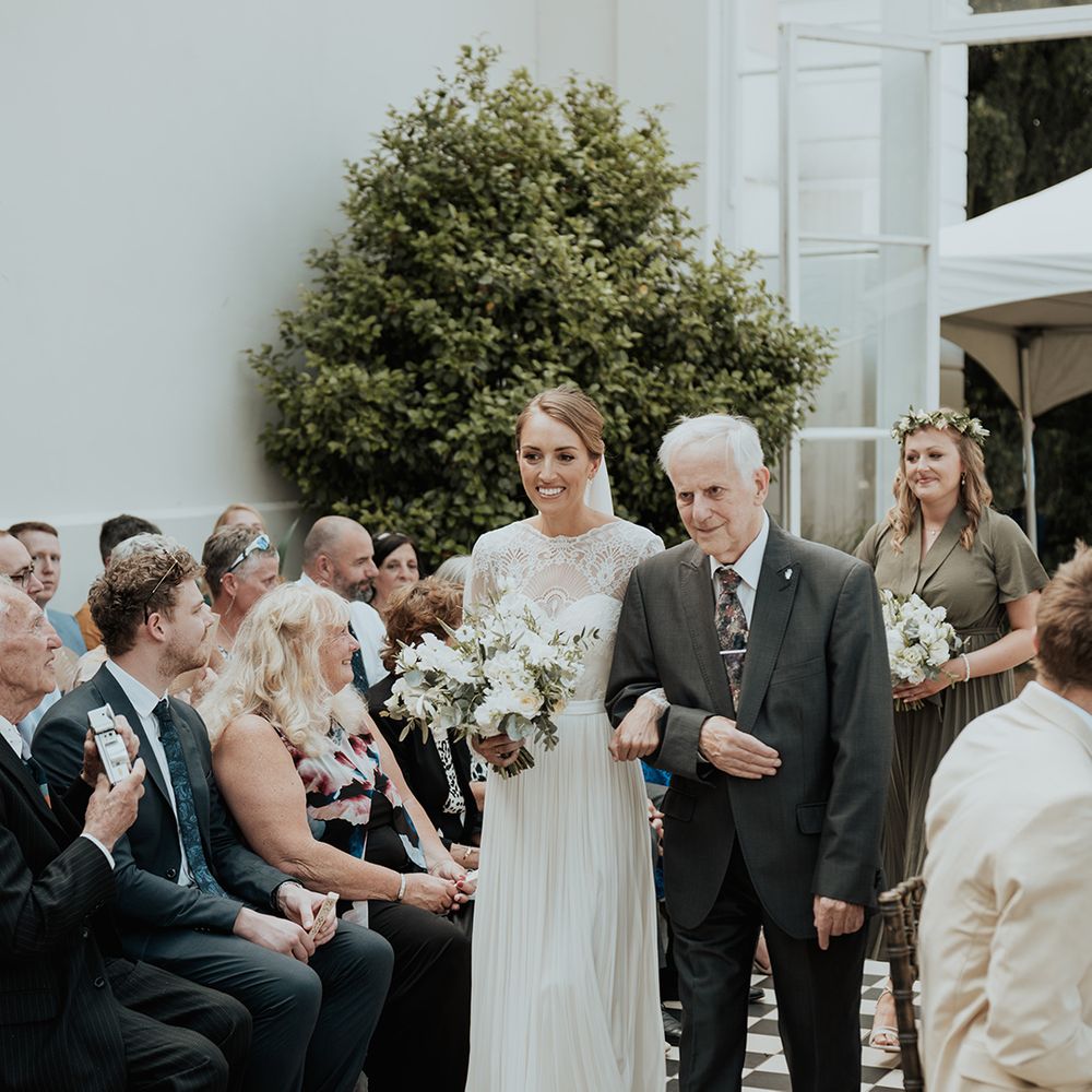 grandfather of the bride walking his granddaughter down the aisle at Gunnersbury Park wedding ceremony 