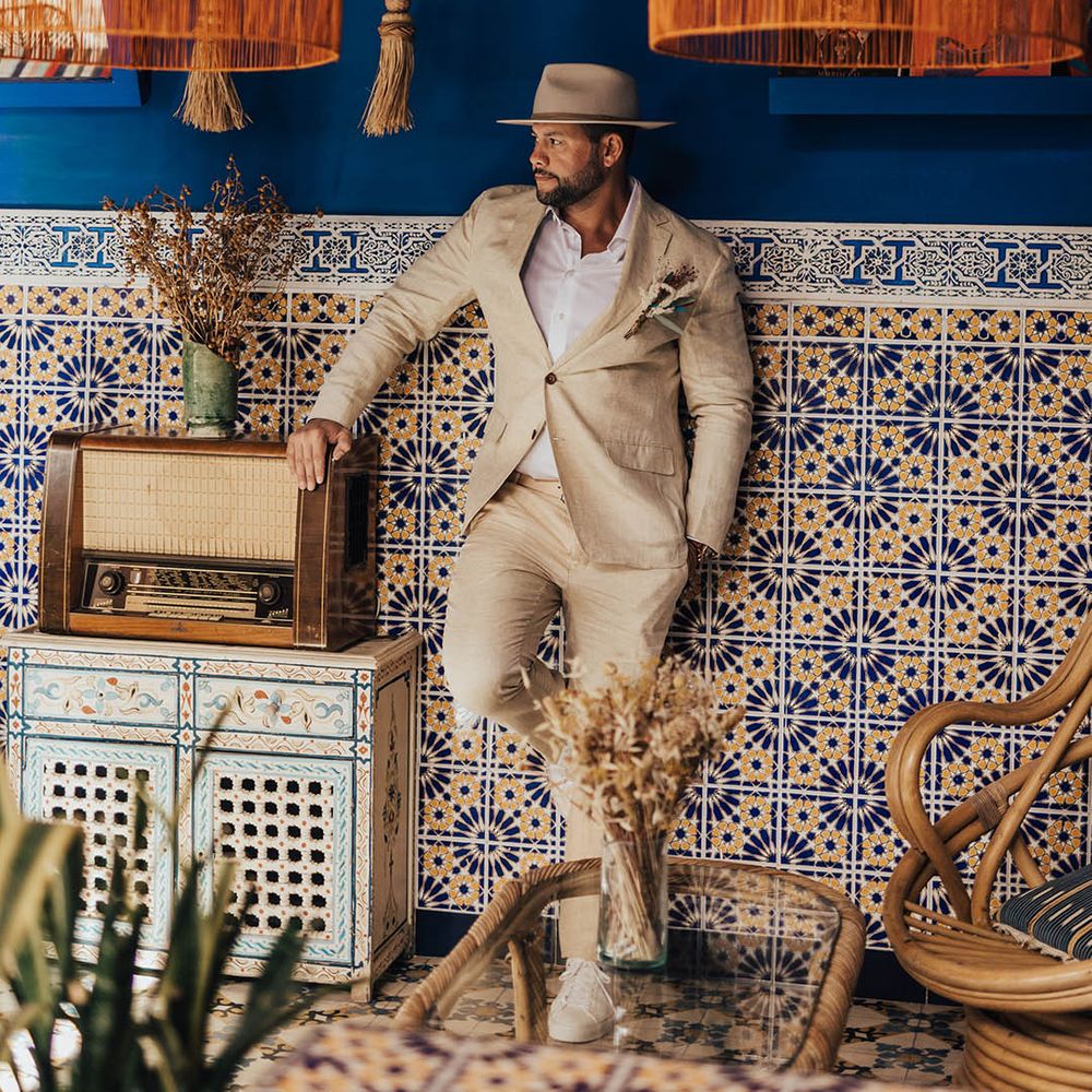 Groom wearing a beige suit and brimmed hat at Morocco wedding venue 