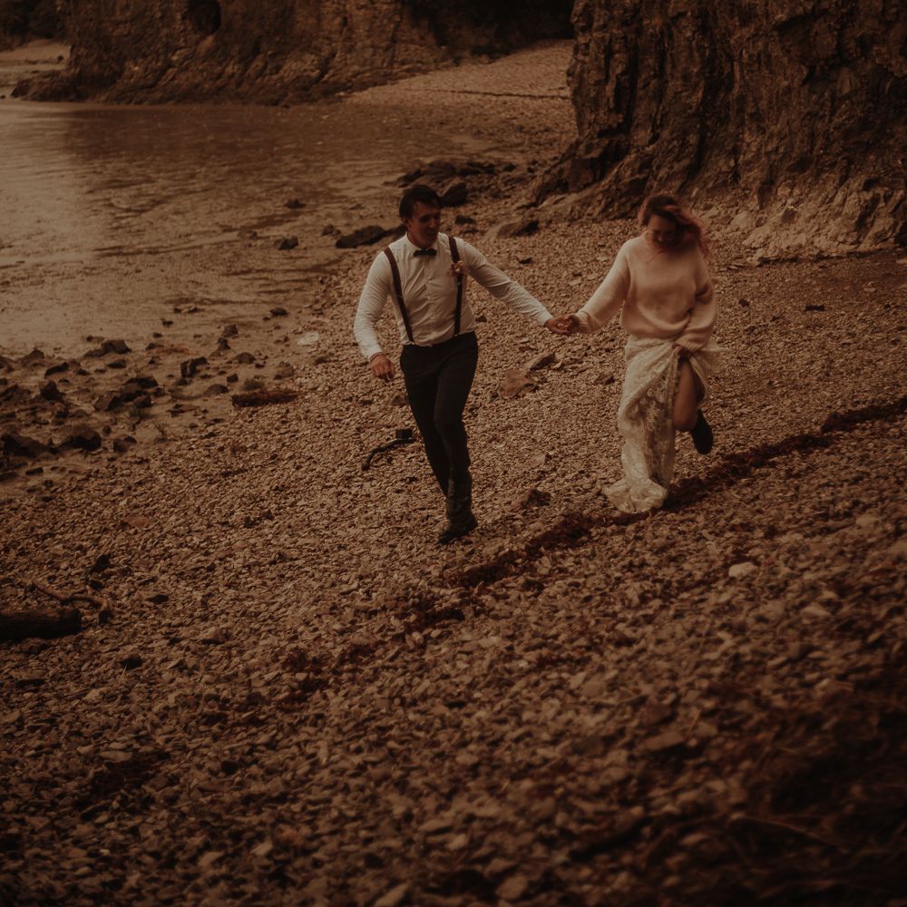Bride and groom holding hands on the beach