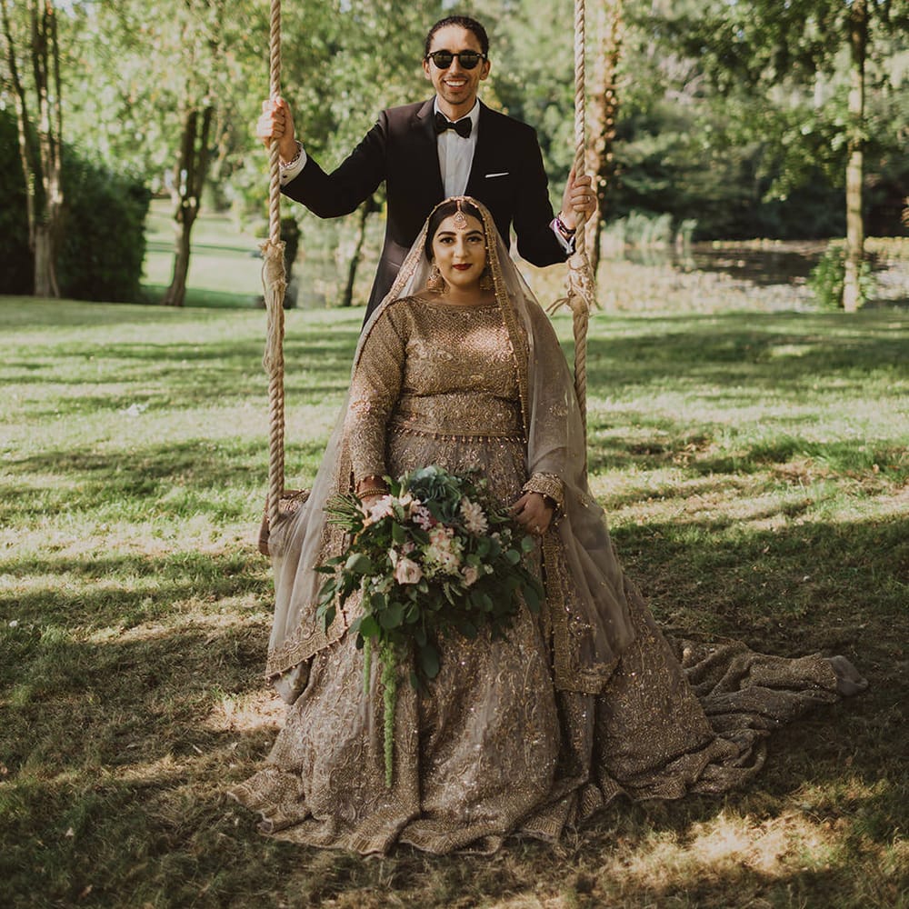 Bride in a gold sari sitting on a swing at Thicket Priory wedding venue in York 