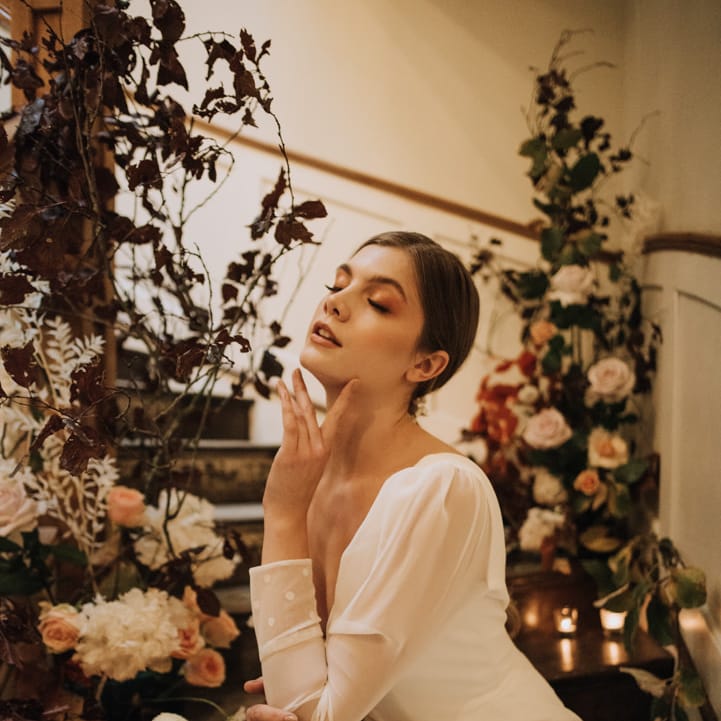 Bride surrounded by autumn flowers and candles
