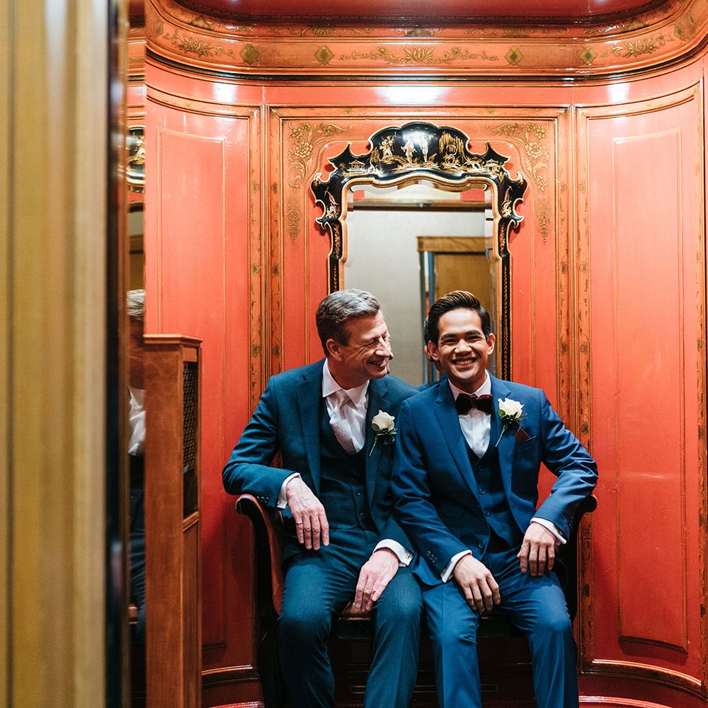 Grooms sit together in blue suits