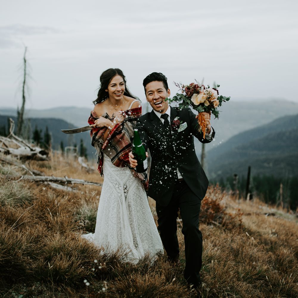 Bride & groom celebrate with champagne with mountains in the background