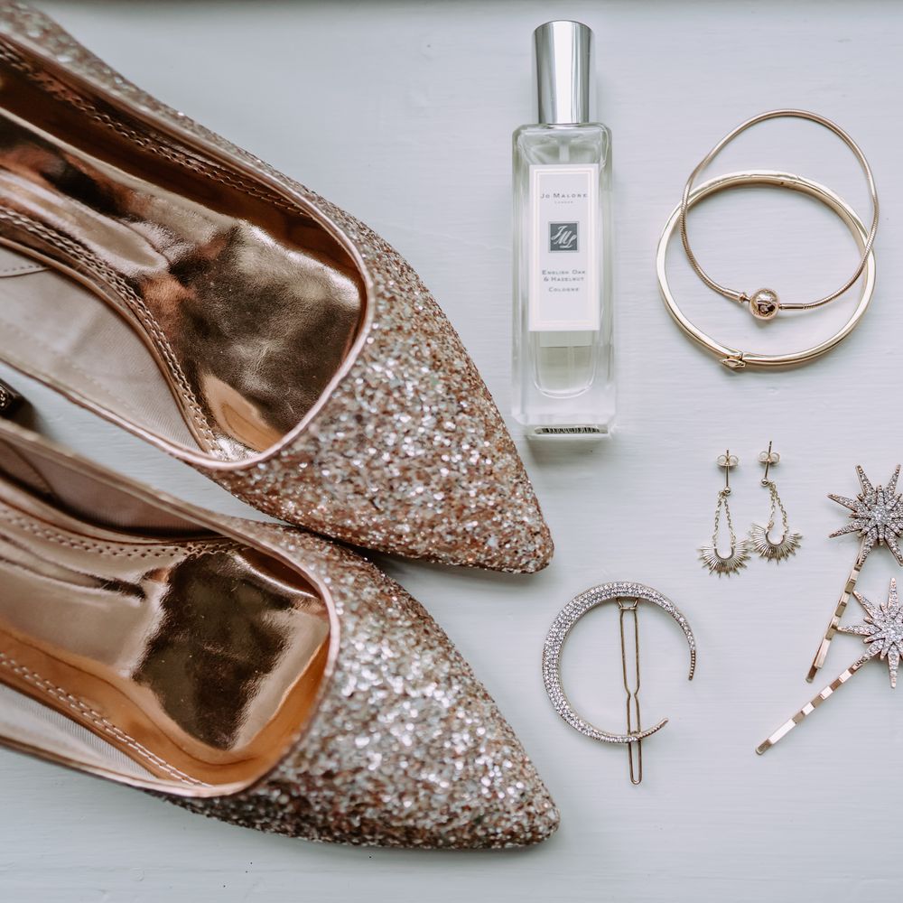 Sequinned shoes next to bridal jewellery and perfume for wedding day