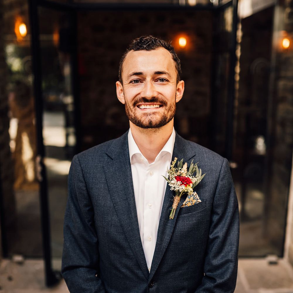 Groom smiles and poses for camera on his wedding day