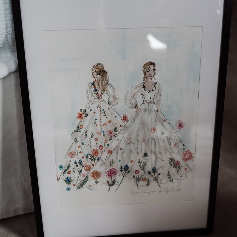 Framed illustration of long sleeve Victoria Sanders wedding dress with floral embroidery