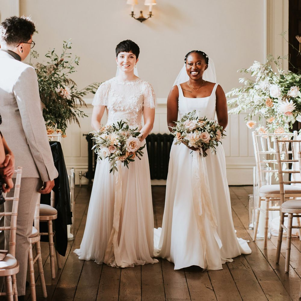 Romantic Elmore Court wedding with two brides holding pink, white and green wedding bouquets tied with ribbon 