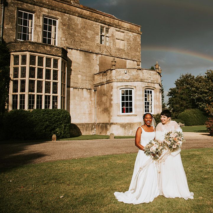 Two brides at LGBTQI+ wedding with rainbow shining 