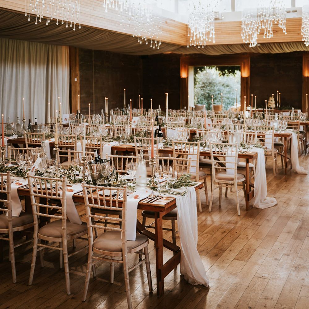 banquet tables at the Gillyflower wedding reception with greenery table runners and candlesticks 