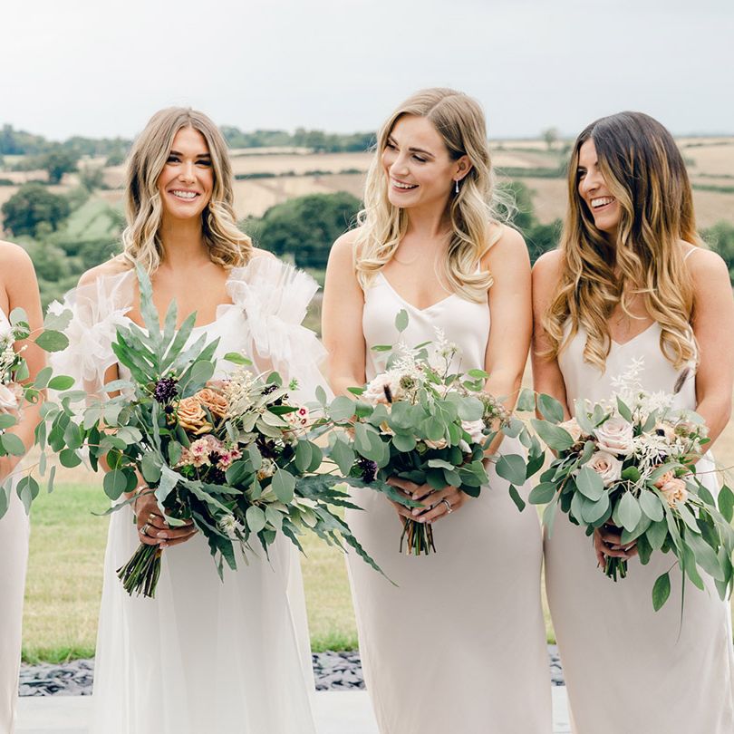 Neutral bridesmaid dresses with bride in Halfpenny London dress with floral bouquets