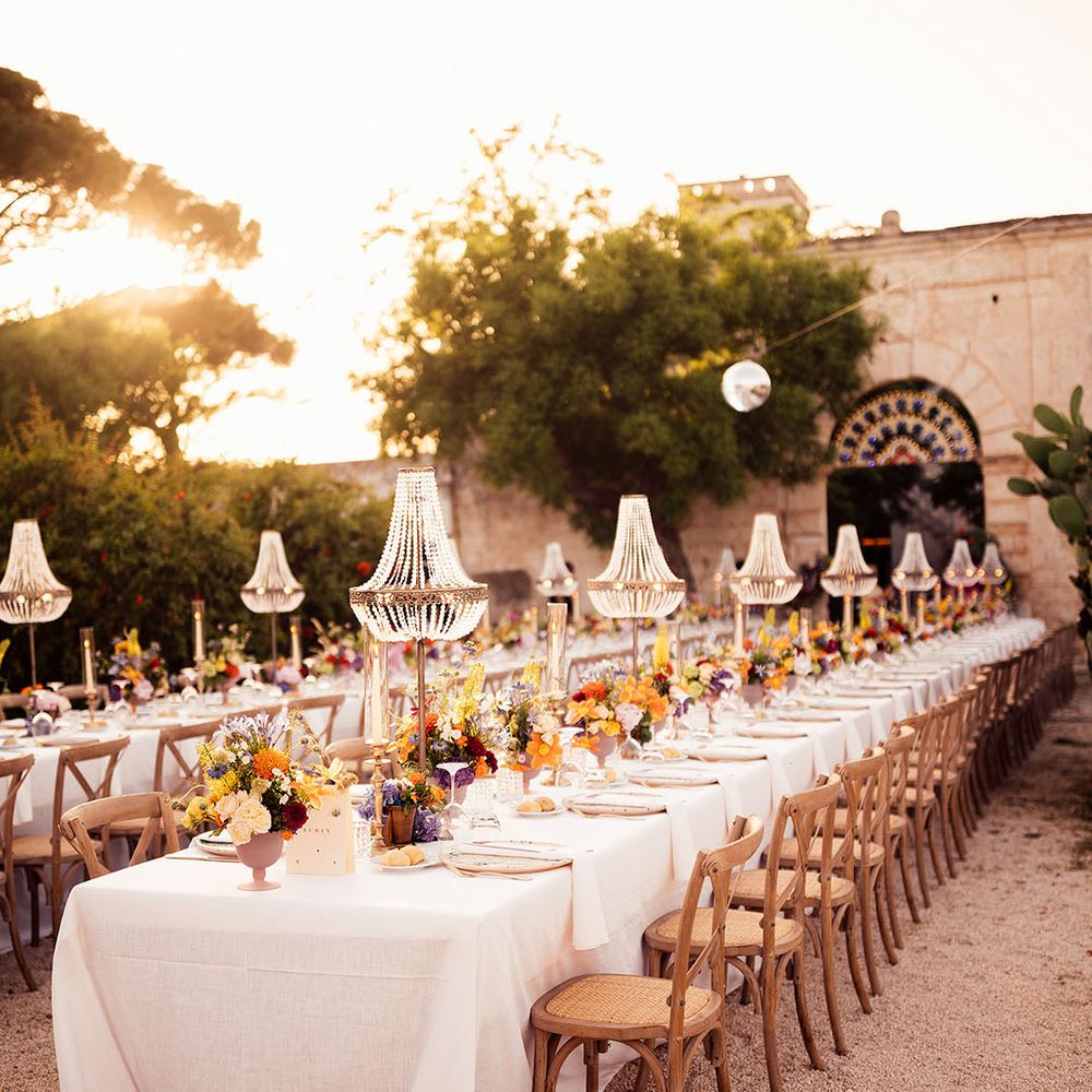 Romantic wedding tablescape with chandelier installation and colourful wedding flower arrangements
