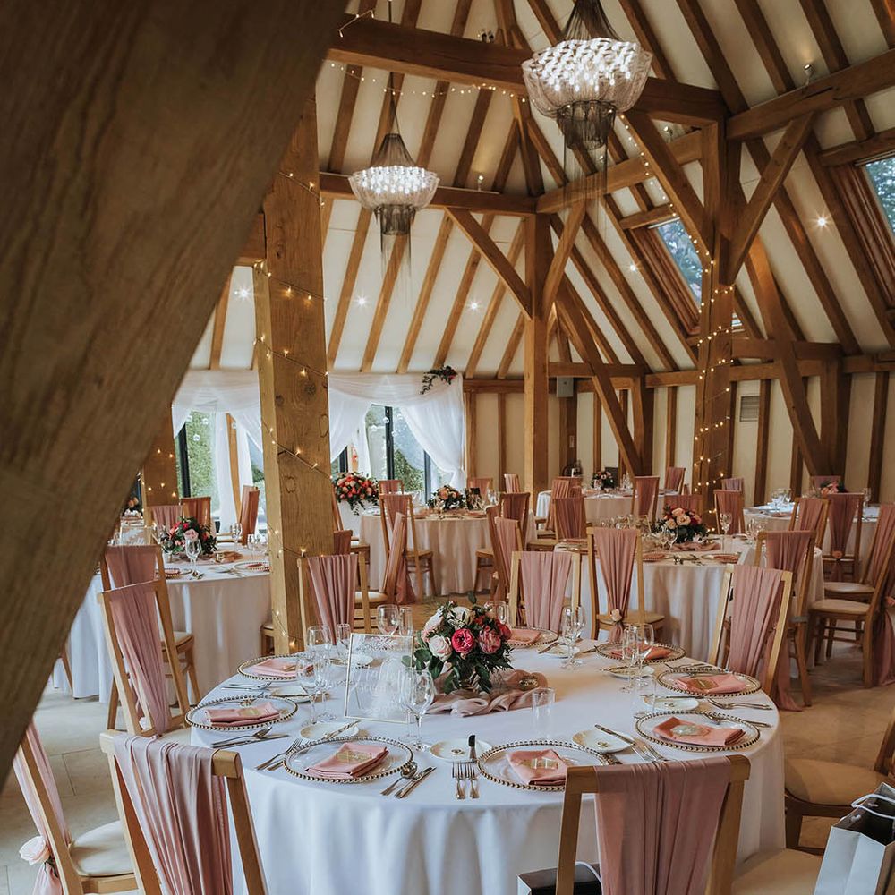 The Old Kent Barn wedding venue with pink and white wedding tablescape 