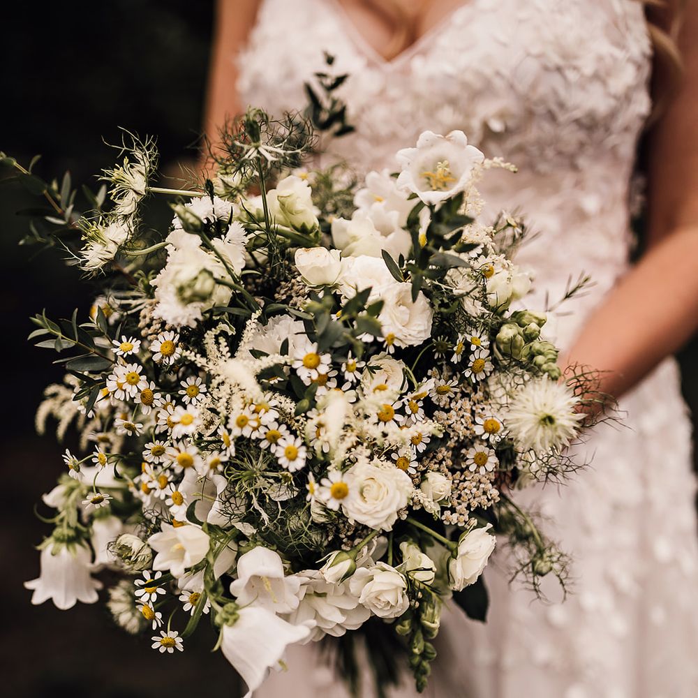 White flower wedding bouquet held by the bride for a rustic barn wedding 