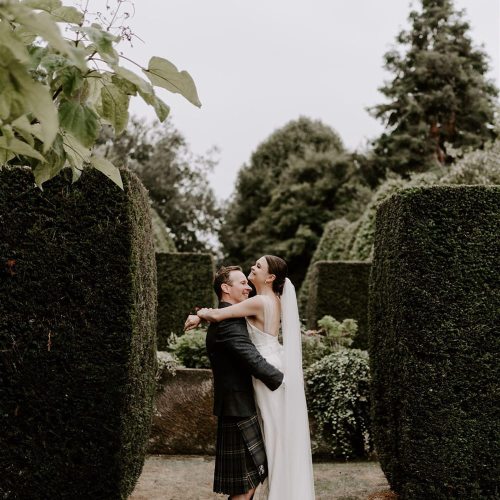 Cute couple portrait of the bride and groom on their wedding day at Pimhill Barn with the groom lifting her up 