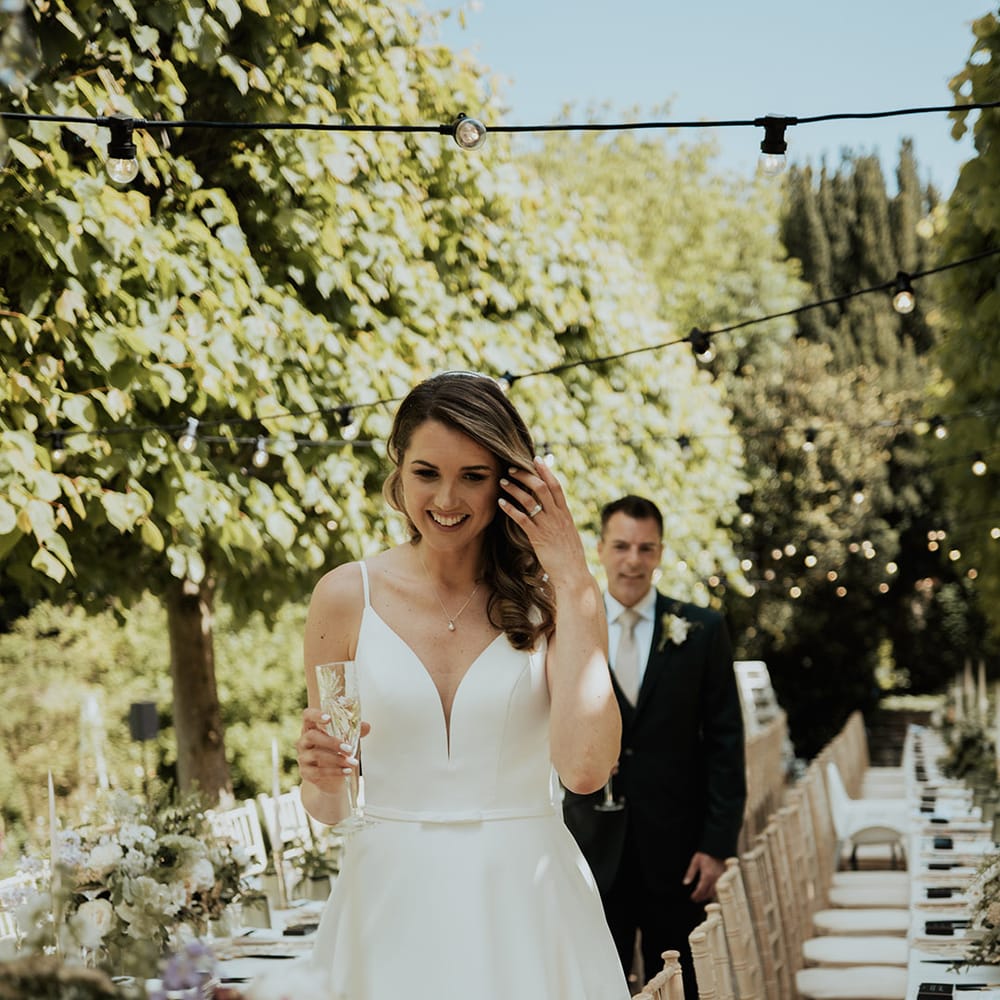 Bride and groom walking around their wedding reception outdoors 