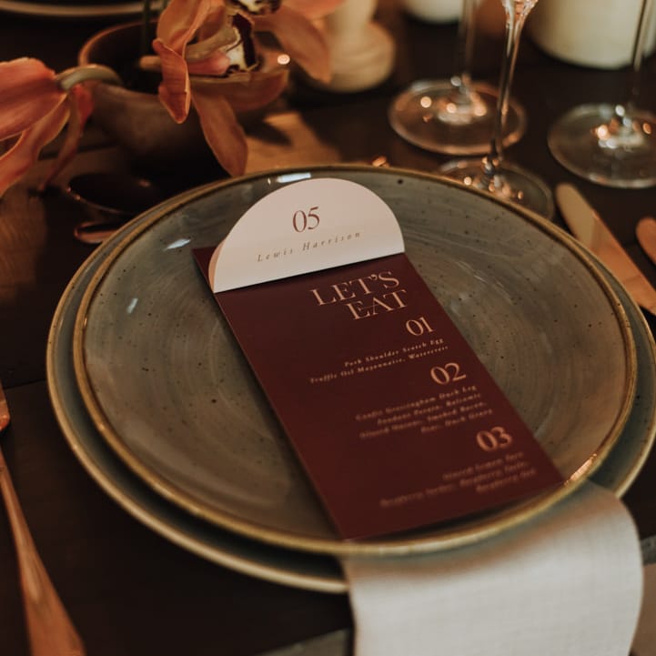 Soft blue linen place setting for wedding with dark menu details