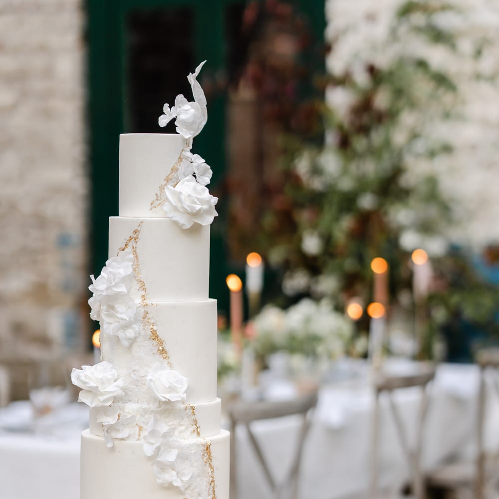 Five tier white wedding cake with gold geode and floral decor and design 