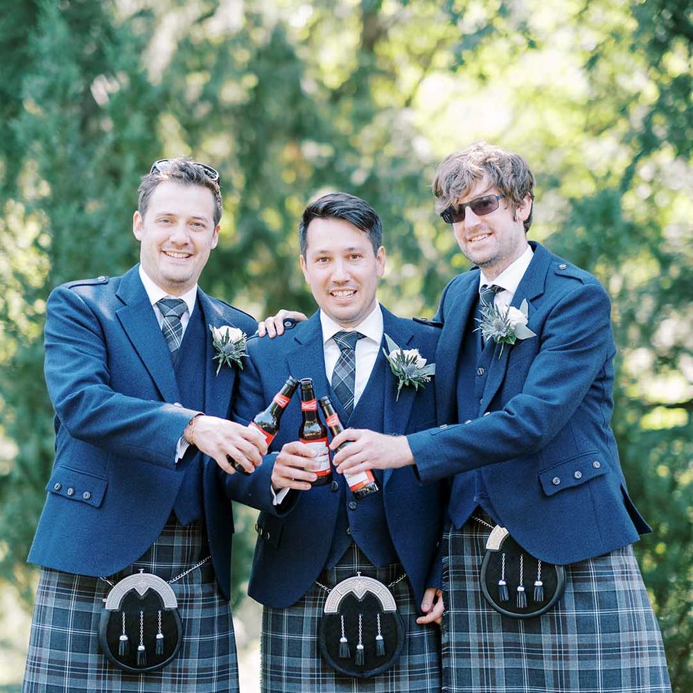 Groomsmen in blue tartan kilts, sporrans and wool blazers for classic Scottish wedding 
