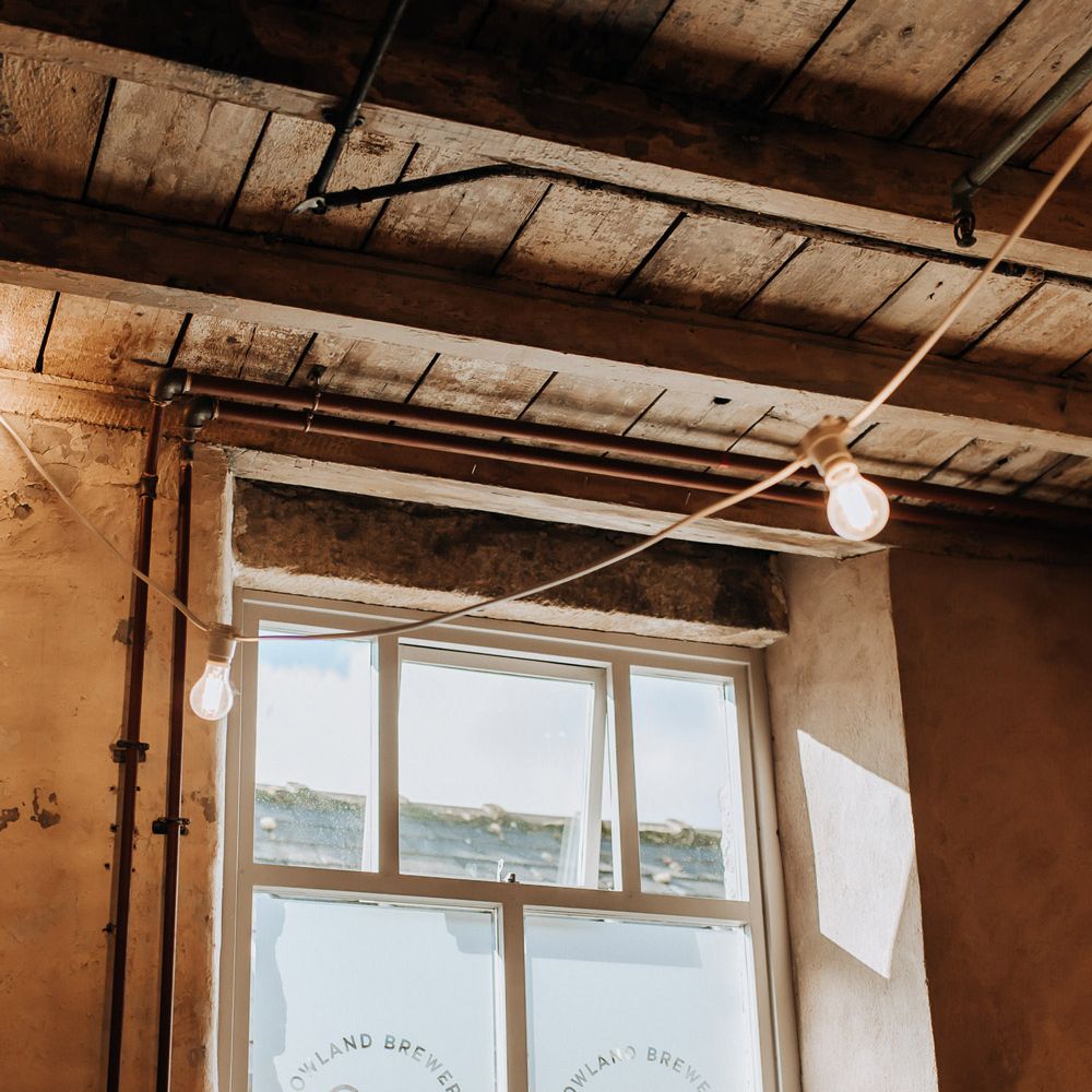 Interior of Mill wedding venue in Lancashire with bulb string lights