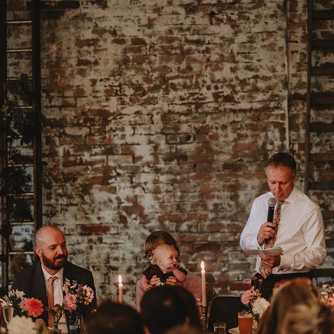 Father of The Bride gives speech at Scale Liverpool in industrial styled setting with exposed brick wall 