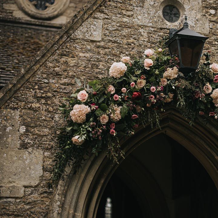 Pink rose and hydrangea wedding flower arch decorating the church wedding