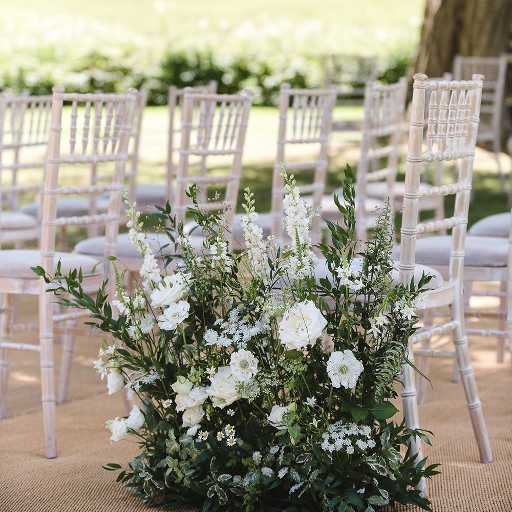 Beautiful white and green wedding aisle flowers with white flowers and foliage 