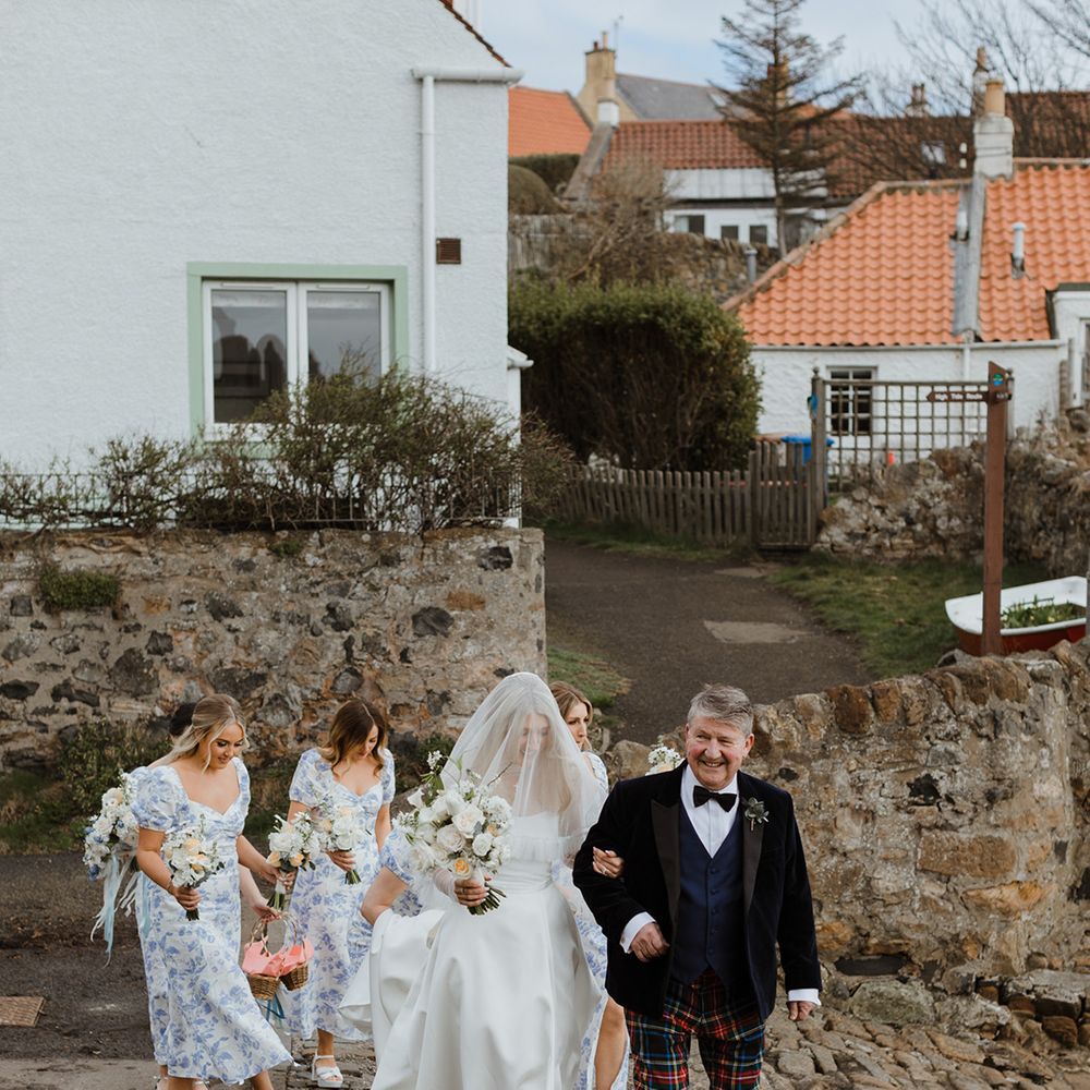 Bridal party and father of the bride walk with the bride to the wedding ceremony at St Monans Kirk