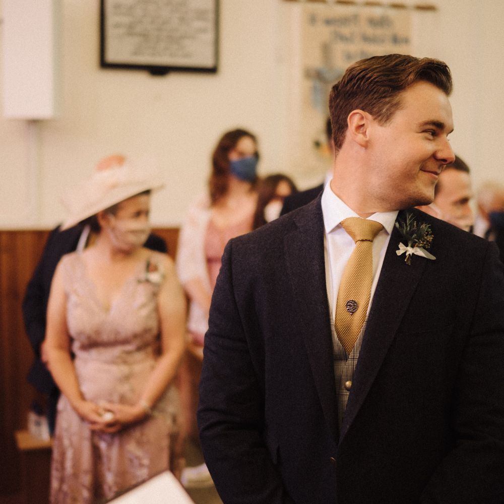 Groom waits at the alter for bride on wedding morning