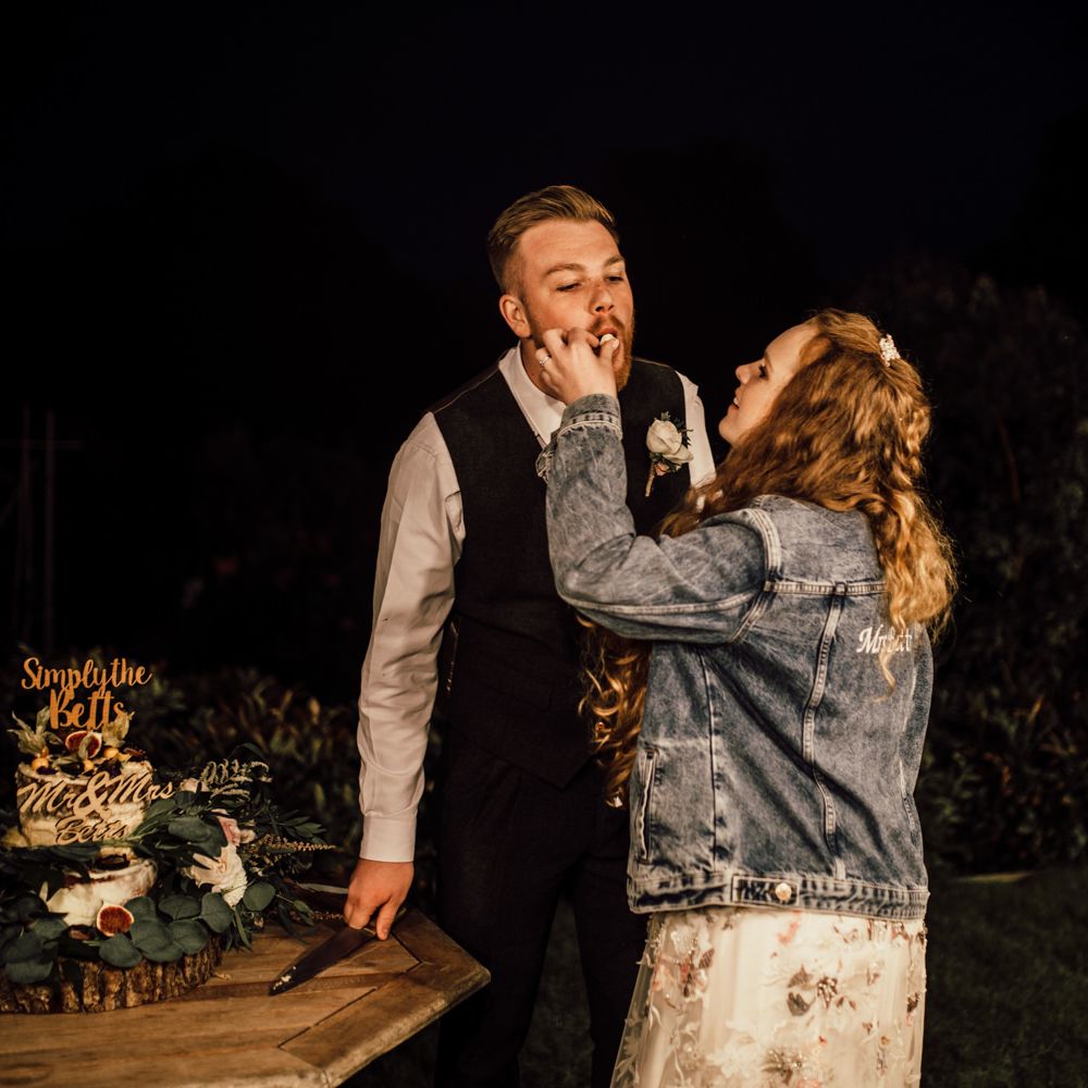 Bride & groom feed each other wedding cake 