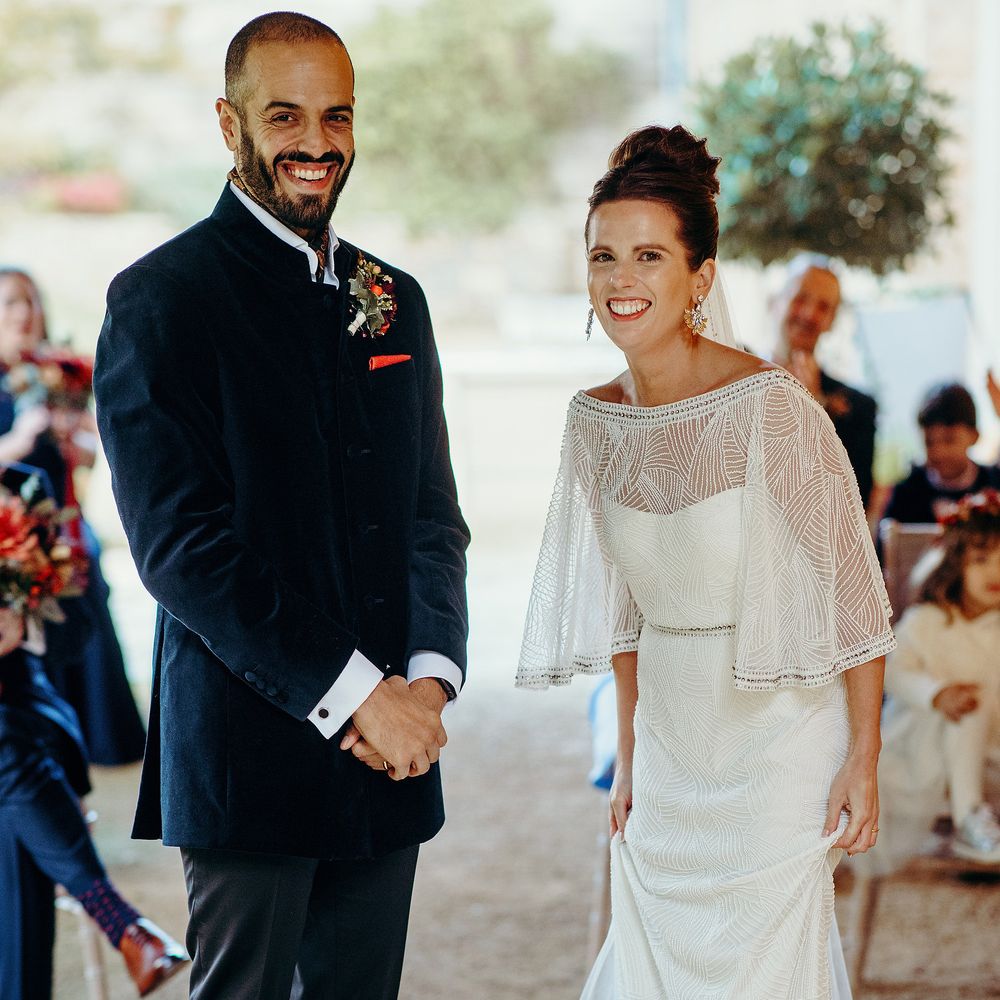 Bride & groom stand together during fairy lit ceremony