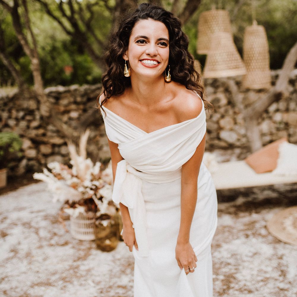 Bride laughs wearing golden statement earrings 
