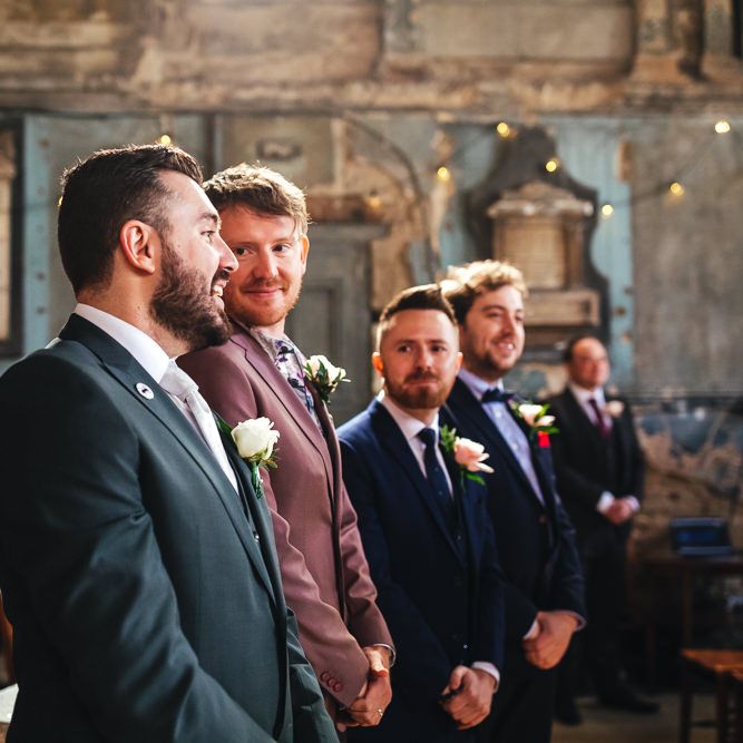 Groom waits with his groomsmen during wedding ceremony