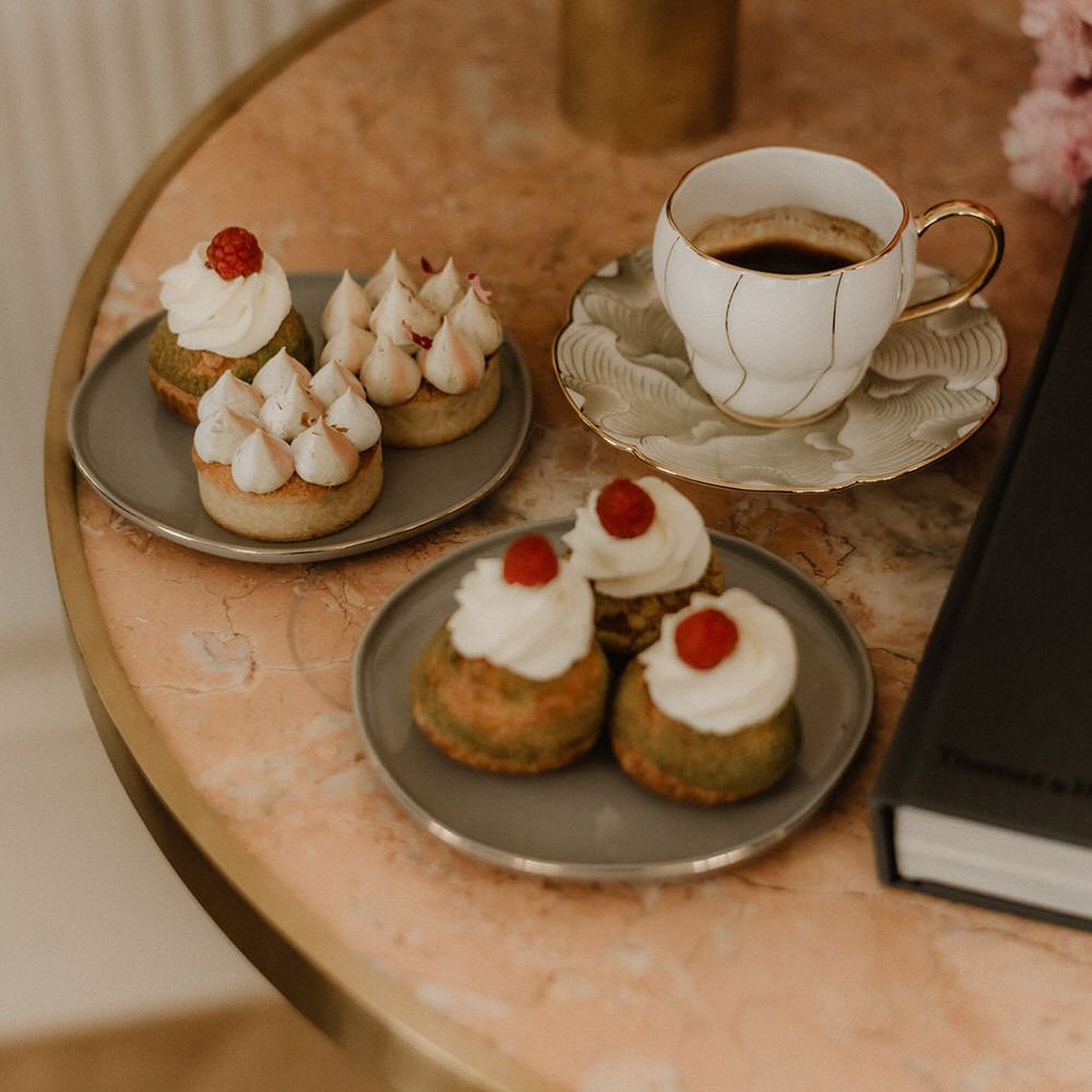 Assorted artisan pastries with a white and gold teacup and saucer